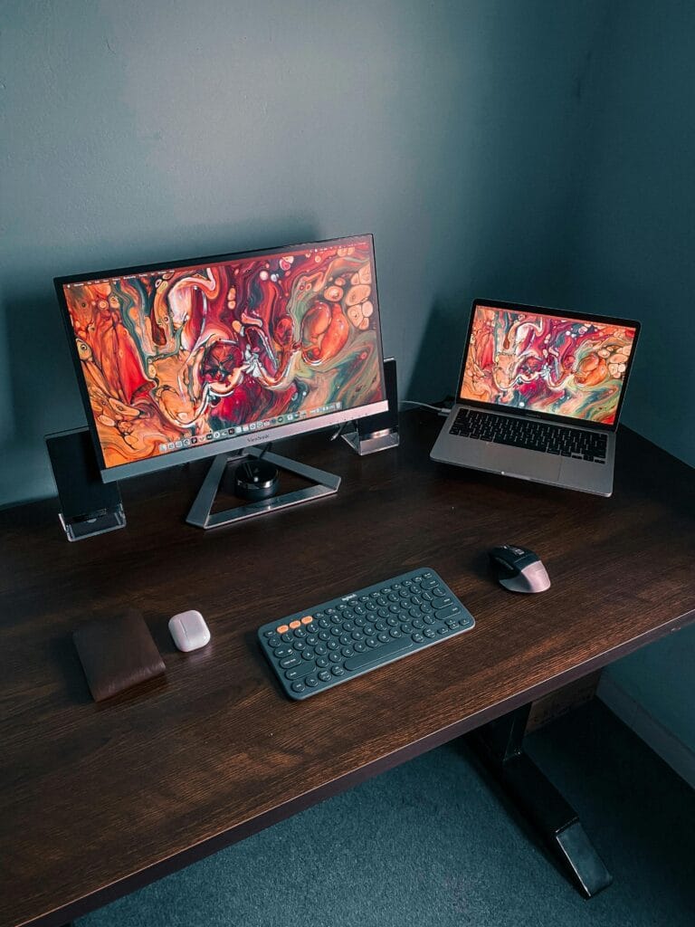 Image Editing workspace with desktop and laptop showing creative digital artwork